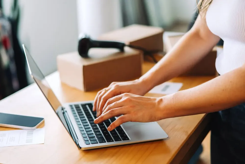 Empresário a preparar encomendas para envio com diferentes transportadoras, representando a escolha logística no e-commerce