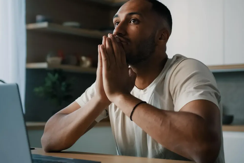 Homme regardant son ordinateur visiblement déçu par l’absence d’informations claires sur la livraison de son colis e-commerce.