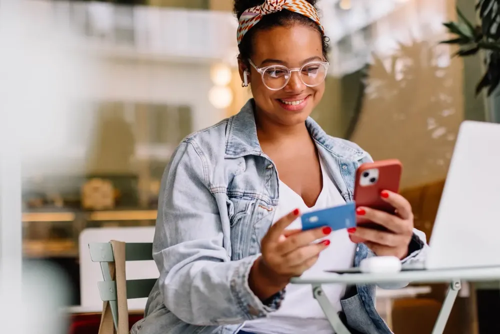 oman entering credit card details on e‑commerce checkout page, illustrating seamless payment and reassuring free returns policy to boost conversion