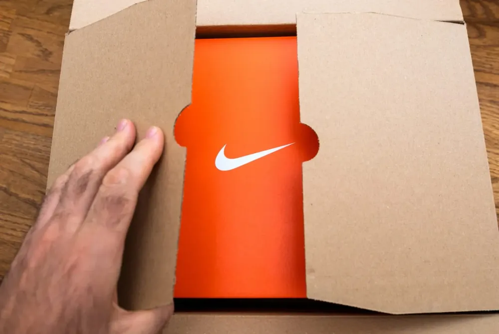 Unboxing a pair of Nike trainers with minimalist packaging and subtle branding — a sleek and premium customer experience.